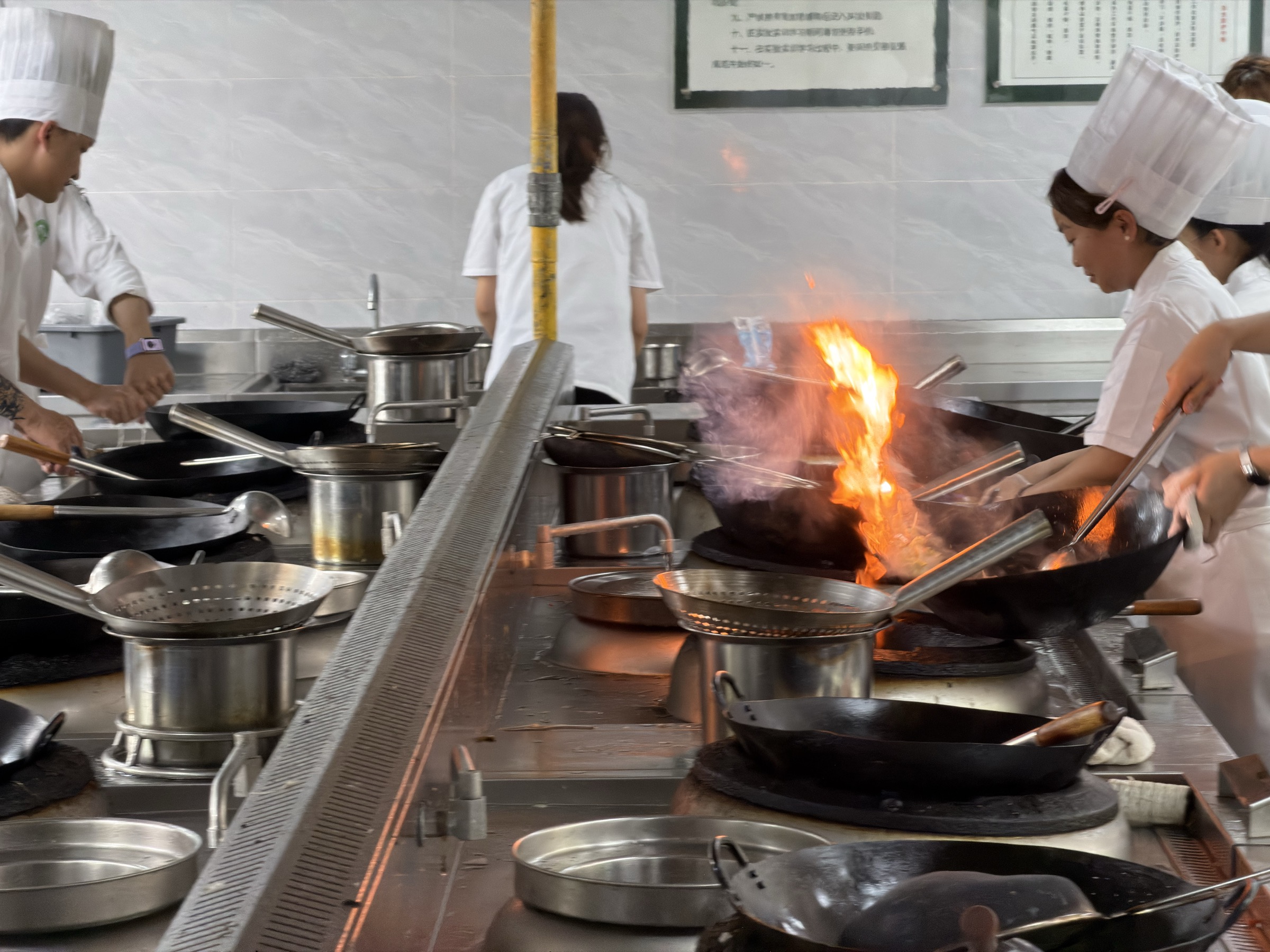 Wok cooking in a professional Sichuan chef training kitchen in Chengdu
